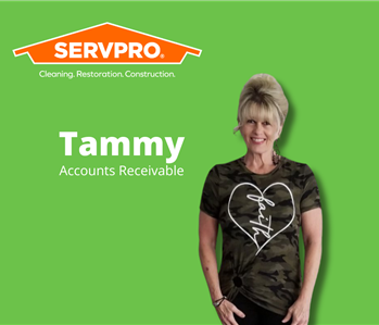 female employee standing in front of green background with servpro logo