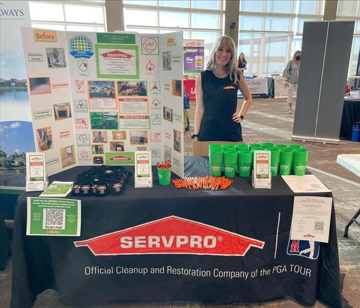 Female servpro employee standing at trade show display