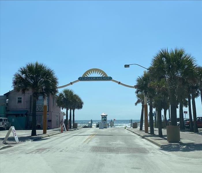 a photo of new smynra beach with the big sign that says flagler avenue on a beautiful spring day.