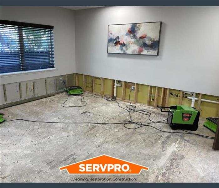 a picture of a foot of drywall removed from a white wall with a servpro logo on the bottom